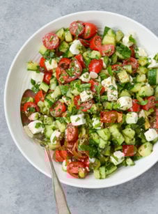 Spoon on a plate with Israeli salad with feta.