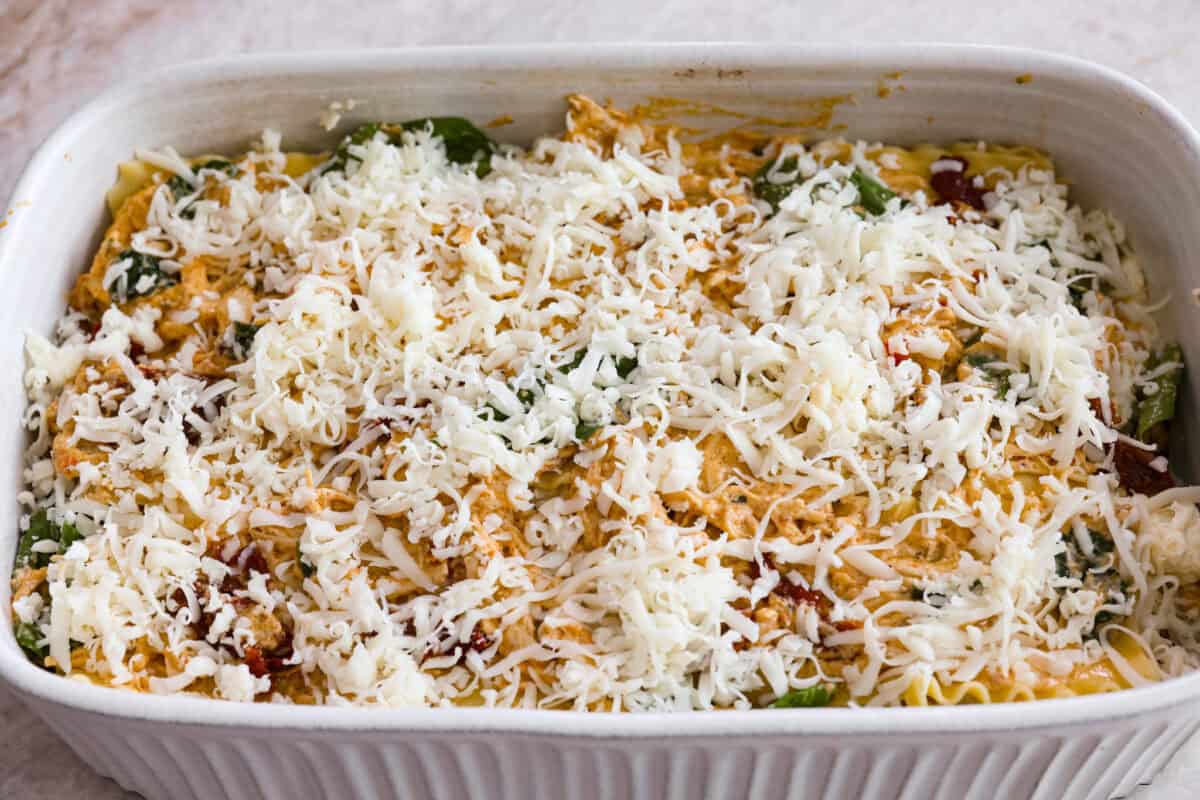 They don’t call it Marry Me Lasagna for nothing! One bite of the creamy sauce, tender chicken, and melty cheese, and everyone will be saying, Last layer of cheese added to the top of the marry me lasagna ready to be covered with foil before it goes into the oven.