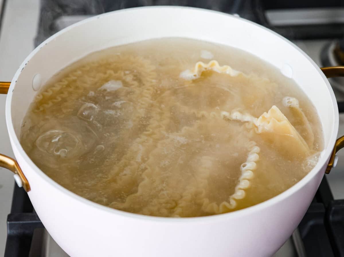 They don’t call it Marry Me Lasagna for nothing! One bite of the creamy sauce, tender chicken, and melty cheese, and everyone will be saying, Lasagna noodles in boiling water in a pot.