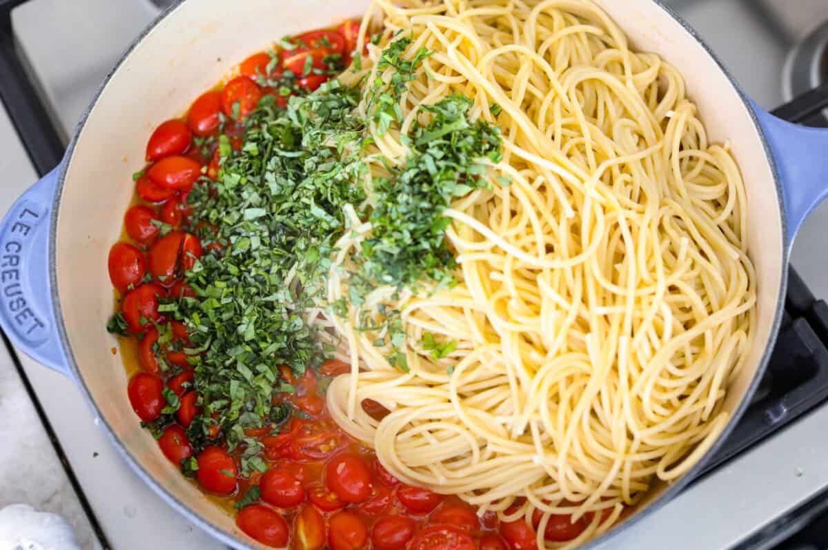 Cooked pasta, and fresh basil added to the skillet with the tomatoes. 