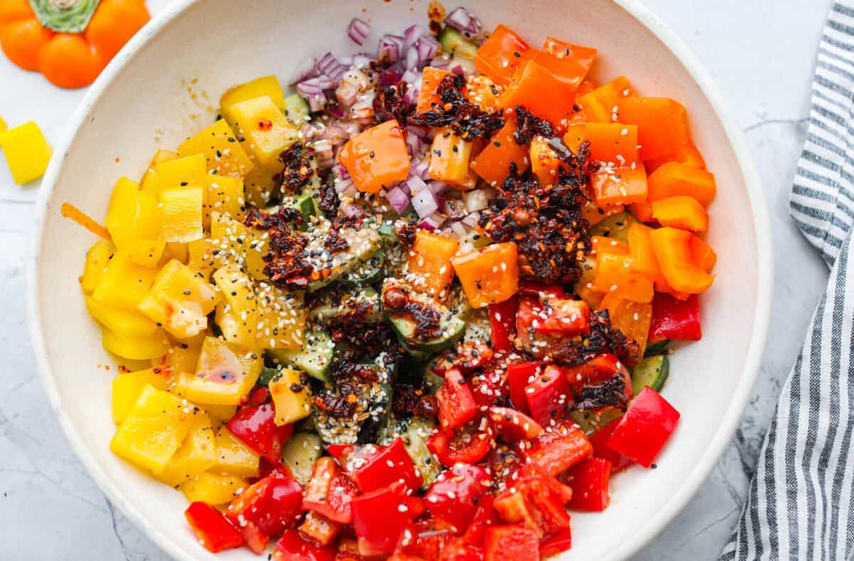 Dressing poured over the vegetables in the bowl. 