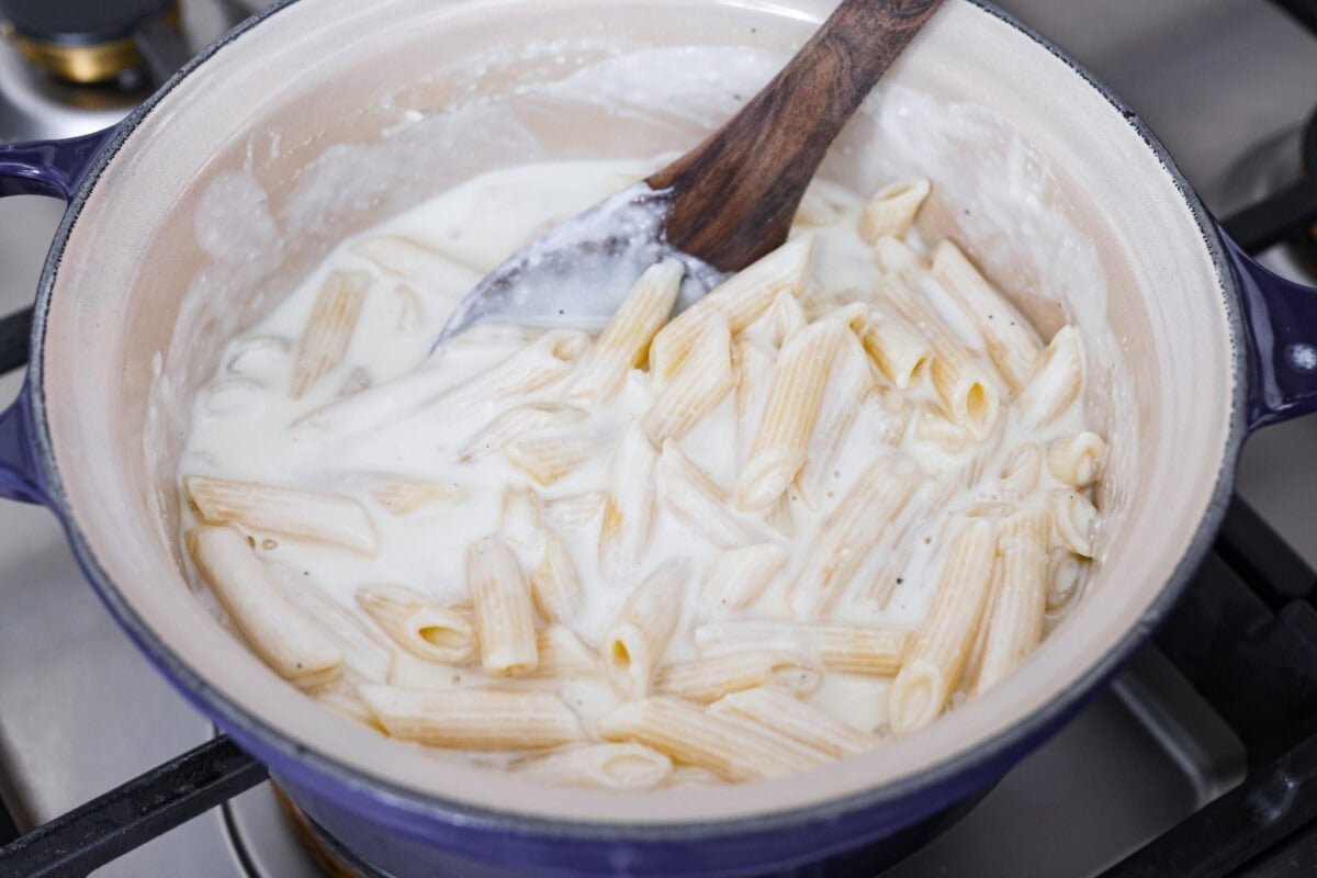 Cooked pasta added back to the pan with he cheesy, creamy sauce. 
