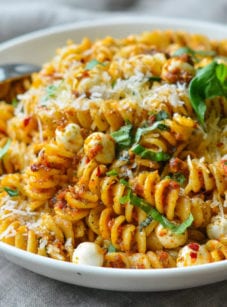 Bowl of pasta with sun-dried tomato pesto and mozzarella pearls.