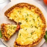 southern tomato pie on platter with tomatoes on the table