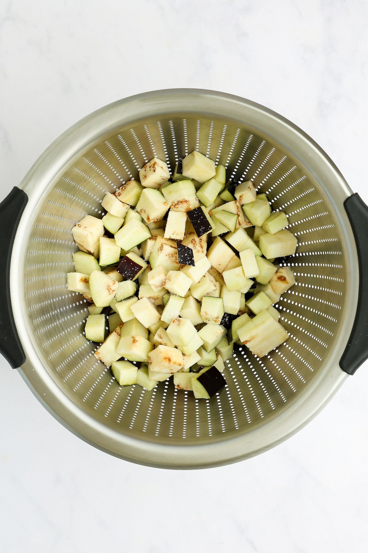 diced eggplant sprinkled with salt in colander