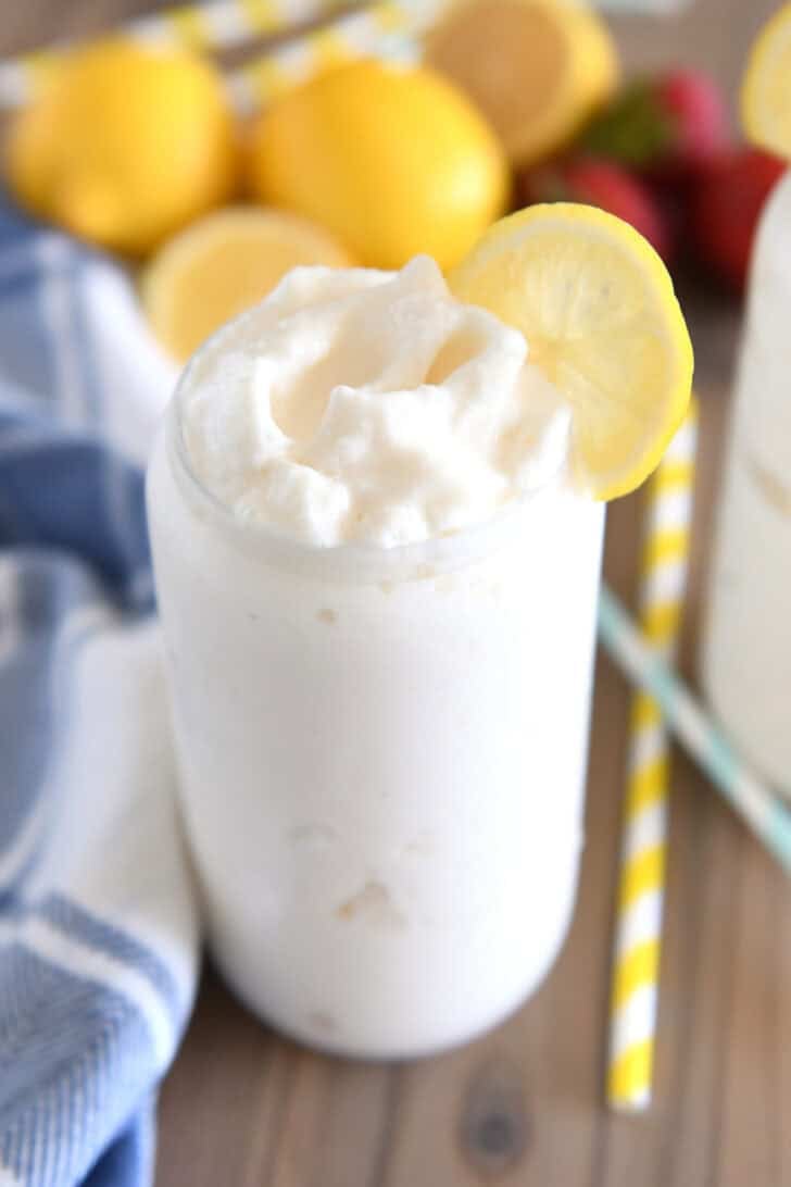 Tall glass filled with frosted lemonade and lemon slice for garnish.