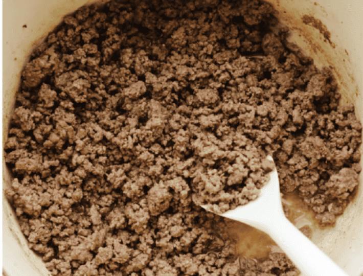 American Goulash is my kind of comfort food! It's rich, savory, and full of that cozy, tomato-y goodness. It’s hearty, easy to make, and one bite will have you hooked just like my family is! Ground beef being cooked in the bottom of the pot.