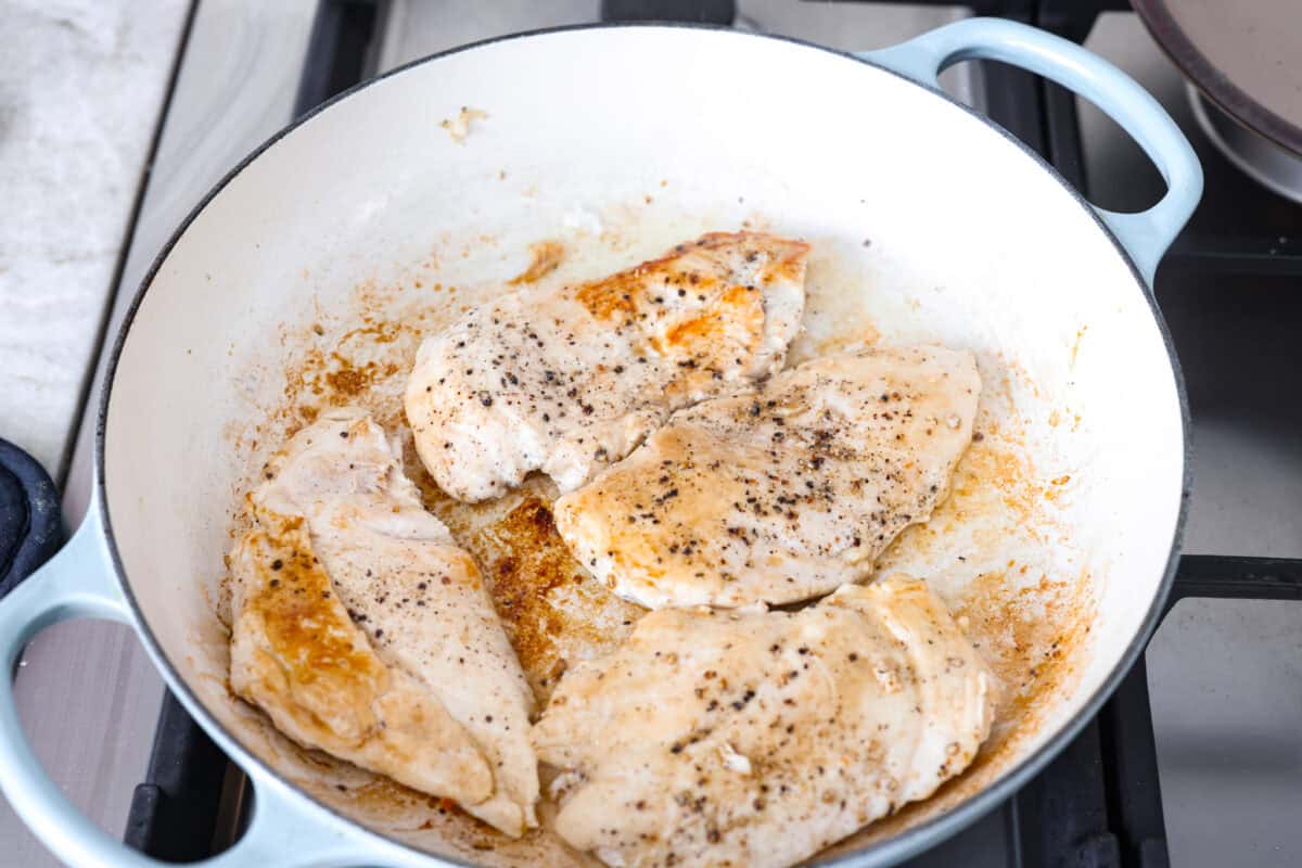 Chicken cooking in a skillet.