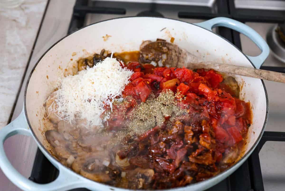 Tomatoes and seasonings added to the mushrooms. 