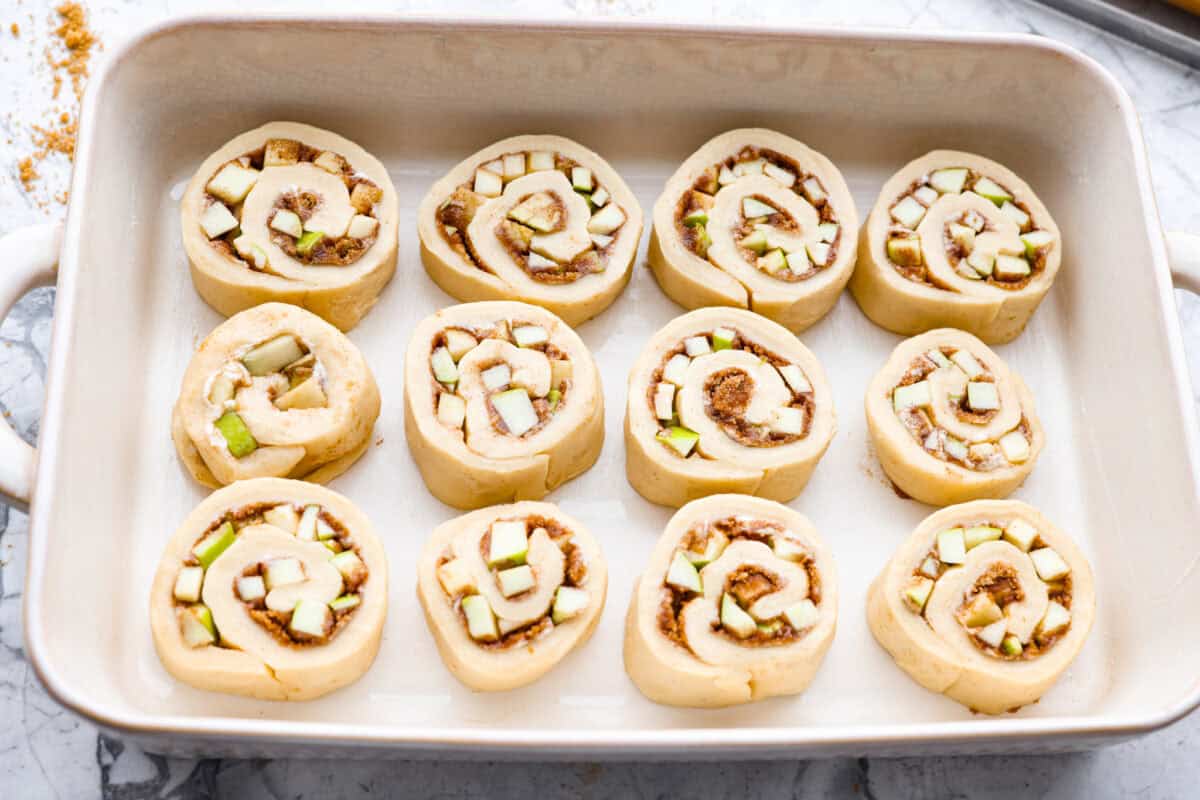 Caramel apple cinnamon rolls sliced, placed in a pan, and read to rise. 