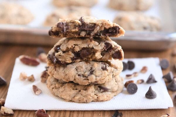 Two cowboy cookies stacked with one cookie broken in half on top.