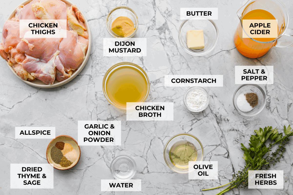 Apple cider chicken thighs bring all the best fall flavors to your plate! Juicy chicken, caramelized apples, and a rich cider sauce for the ultimate cozy dinner. Overhead shot of labeled ingredients.