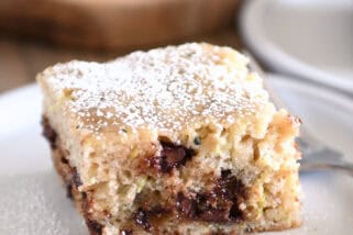 Square piece of zucchini chocolate chip cake on gray plate.