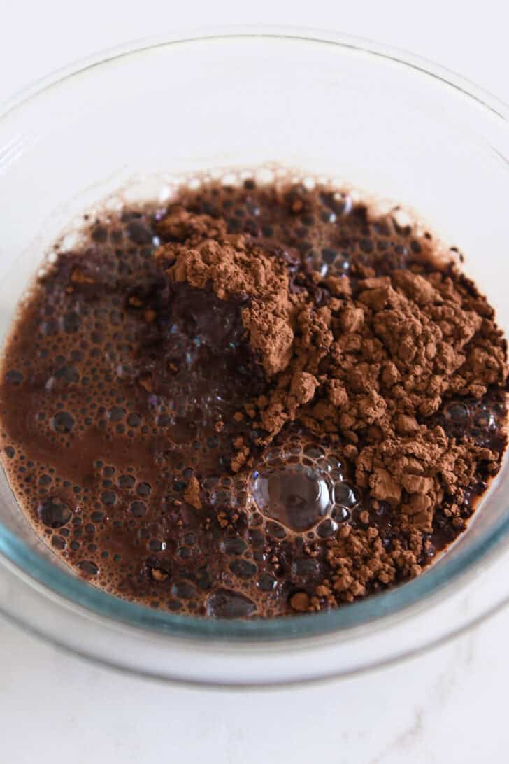 Glass bowl with boiling water and cocoa powder.