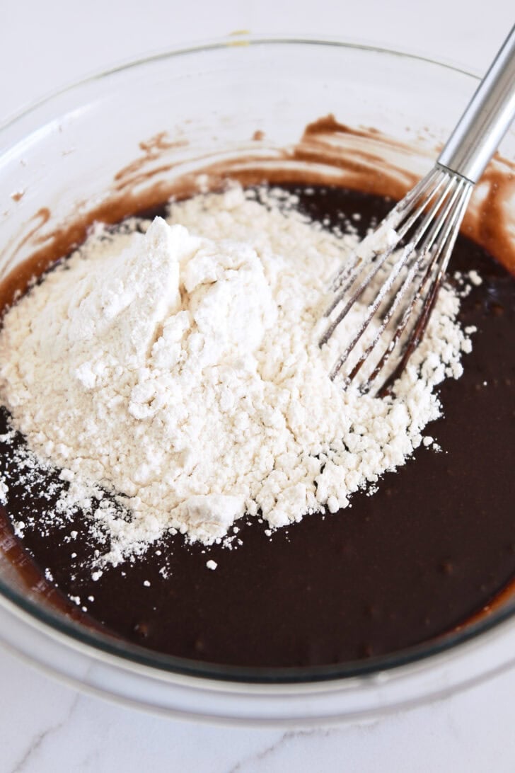 Whisk in bowl with chocolate cake batter and white flour.