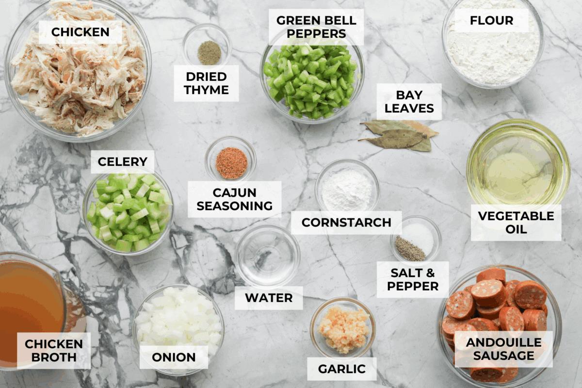 Overhead shot of labeled chicken and sausage gumbo ingredients.