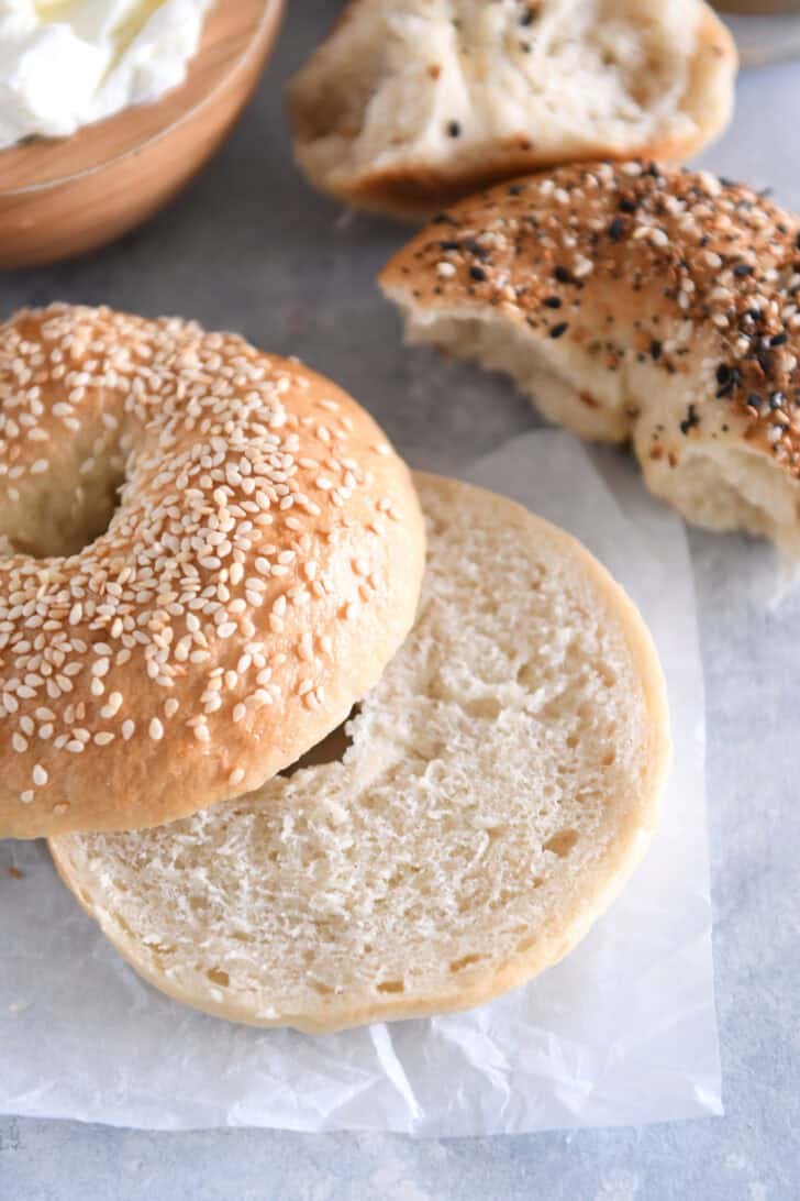 Homemade bagel topped with sesame seed and cut in half.