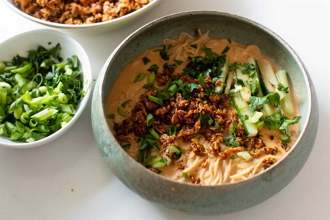 Miso peanut ramen in a bowl with tofu and cucumbers on top.