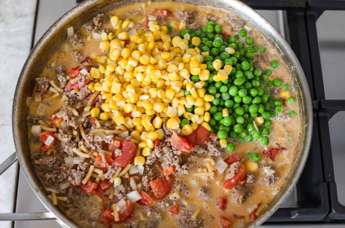 Shipwreck casserole is the ultimate “use what you’ve got” comfort food! Layer it with rice, potatoes, or pasta, toss in any veggies on hand, and make it as cheesy as you like. It’s hearty, budget-friendly, and nearly impossible to mess up! Veggies added to the skillet.