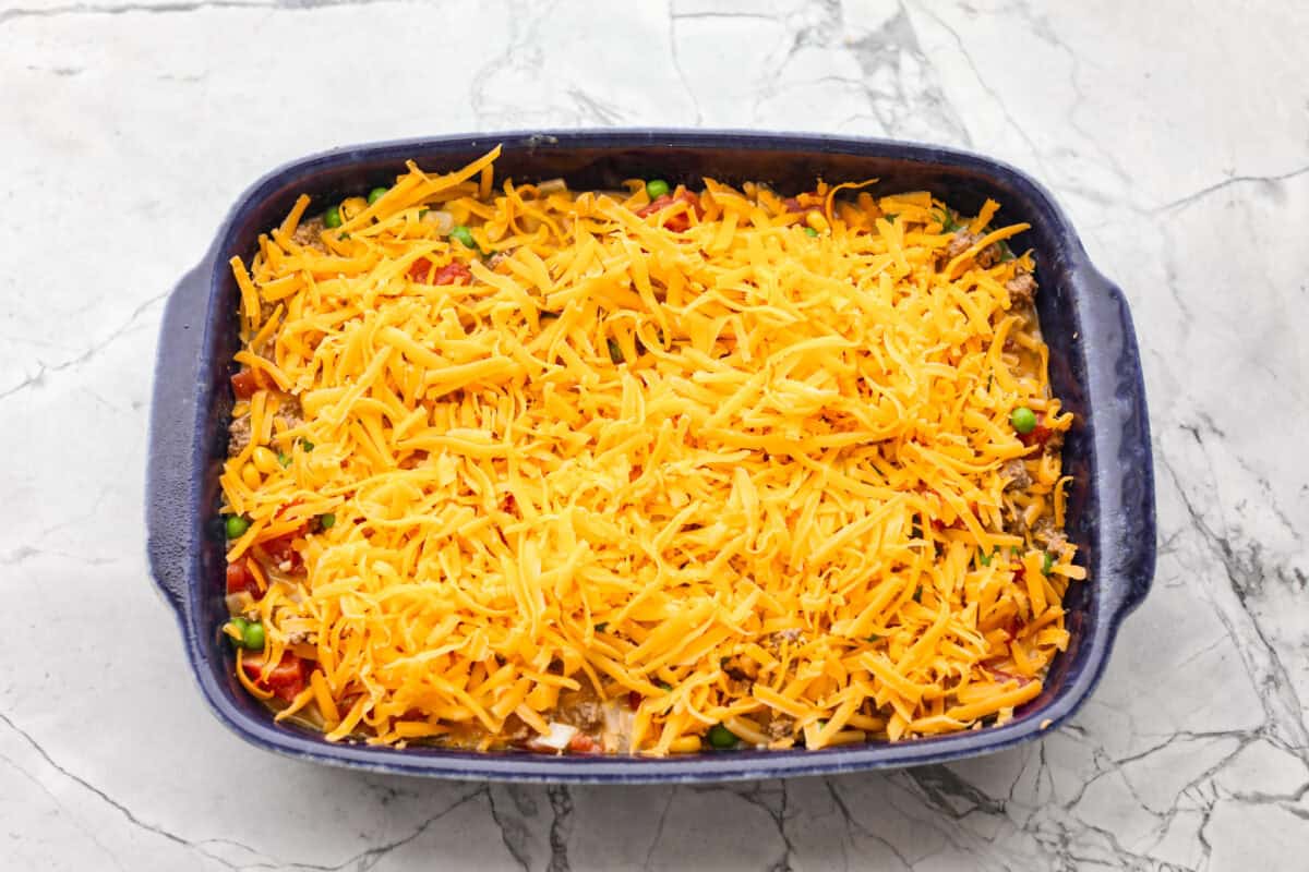 Shipwreck casserole is the ultimate “use what you’ve got” comfort food! Layer it with rice, potatoes, or pasta, toss in any veggies on hand, and make it as cheesy as you like. It’s hearty, budget-friendly, and nearly impossible to mess up! All of the ingredients added to the baking topped with cheese and ready to go in the oven.