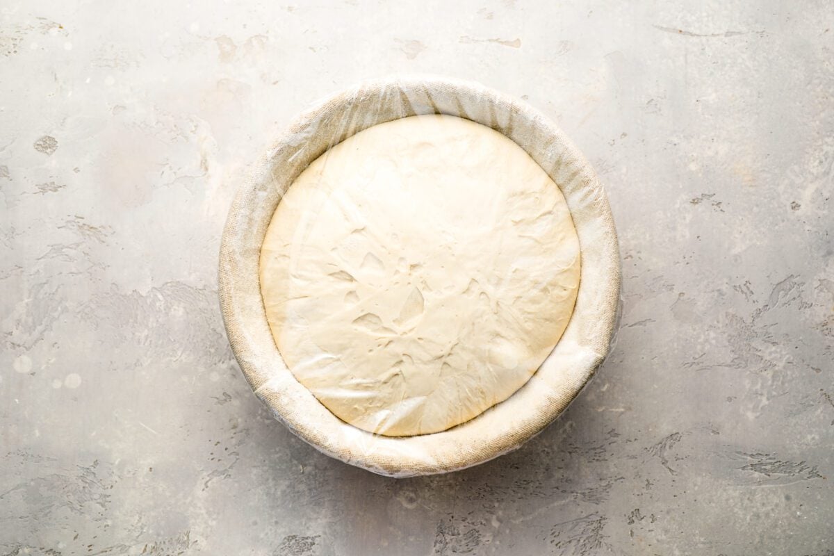 bread dough in bowl lined with a floured towel