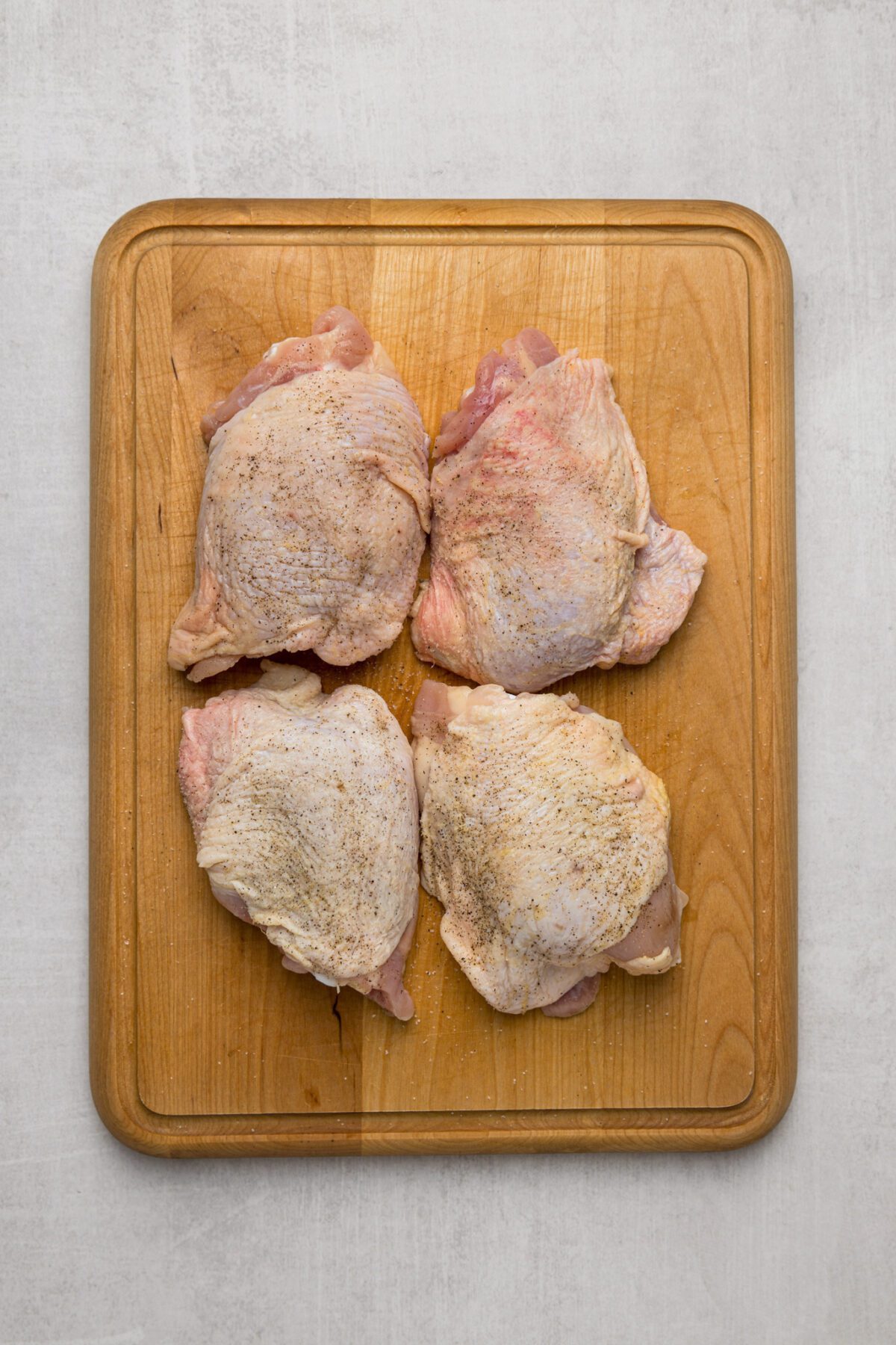 4 chicken thighs on cutting board