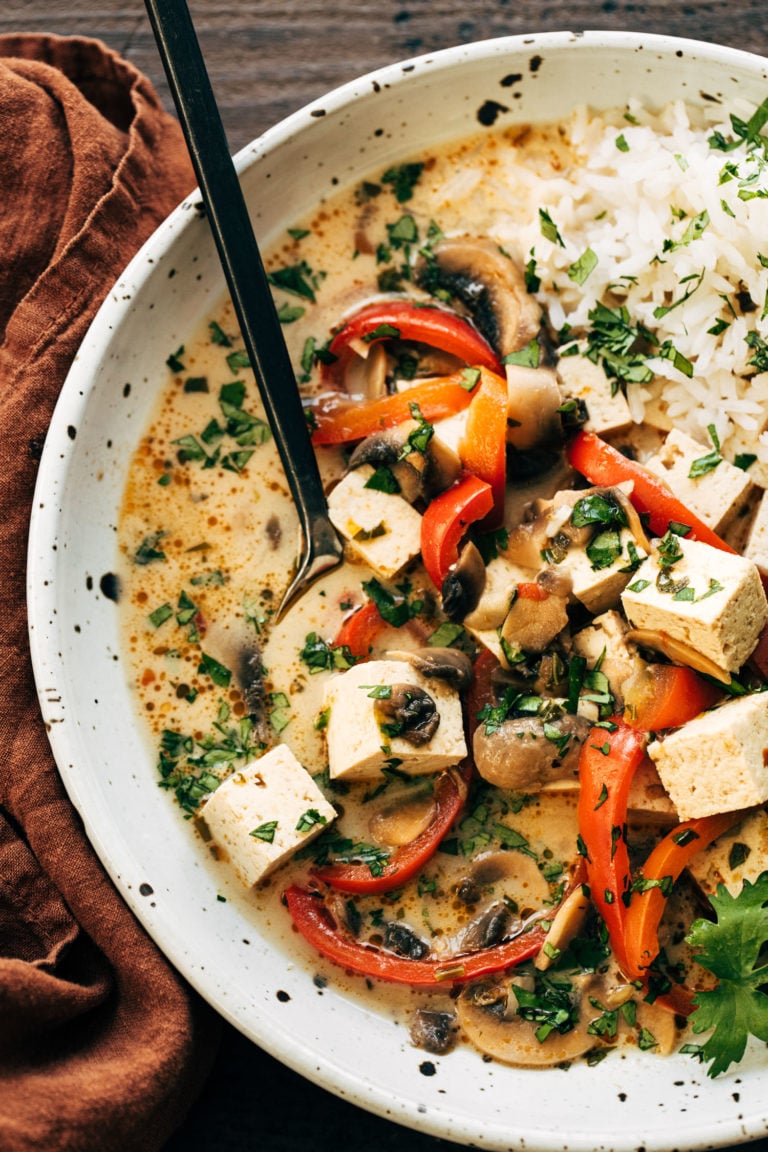 Thai coconut soup in a bowl with rice with a spoon.