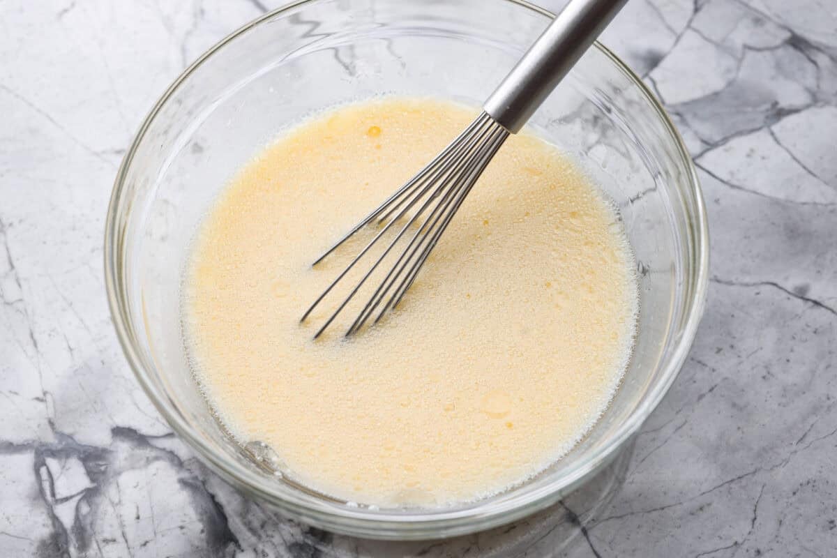 There’s nothing like my homemade Belgian waffles! They're crisp on the outside, soft and fluffy inside, with deep pockets for all the syrup and butter. The secret is whipping the egg whites for that light, airy texture! Wet ingredients added to a bowl and whisked together.