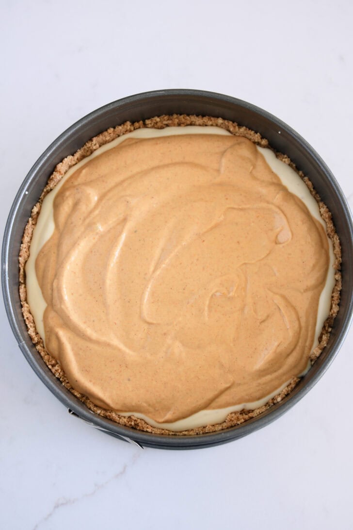 Top down view of 9-inch springform pan, cheesecake batter and pumpkin cheesecake batter.