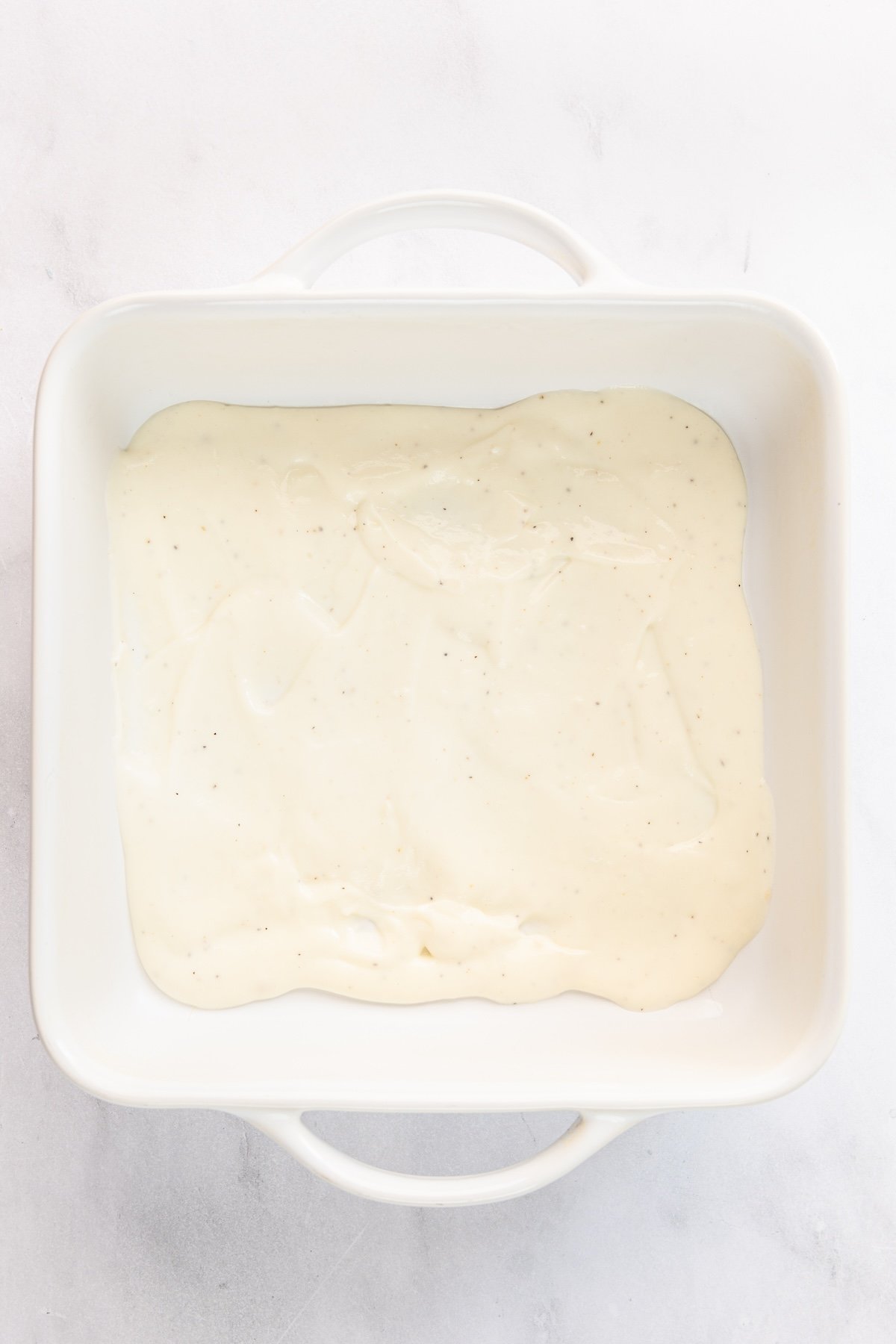 1/3 of bechamel sauce spread on bottom of 8 inch square baking dish