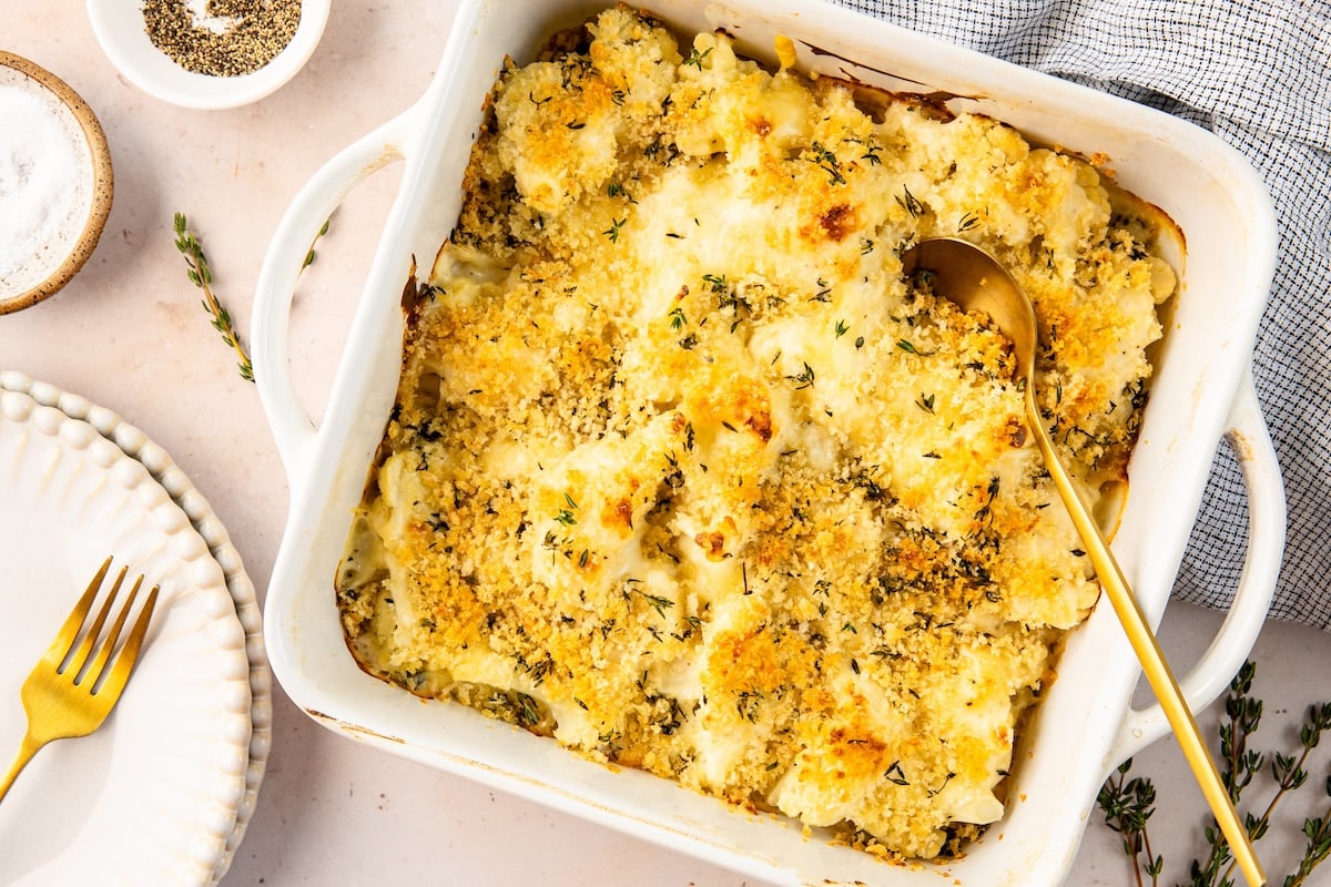 baked cauliflower gratin with serving spoon inserted into it