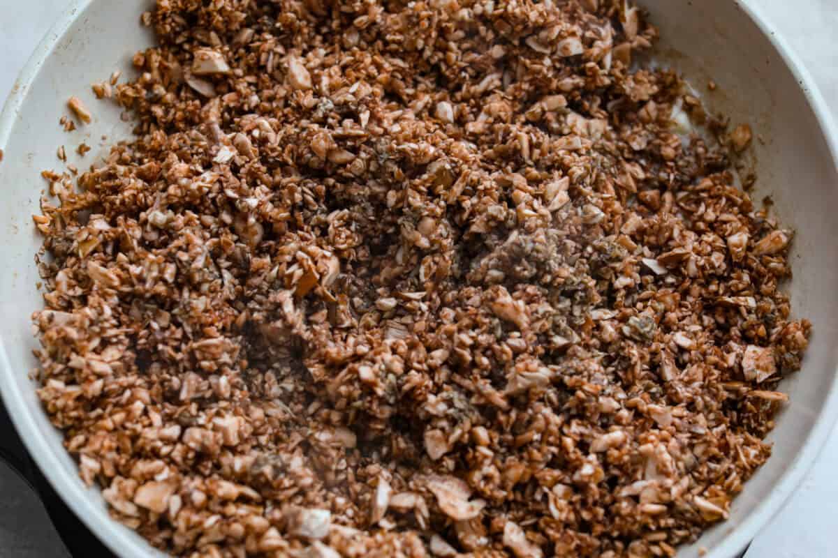 Mushrooms and. butter cooking in a skillet.