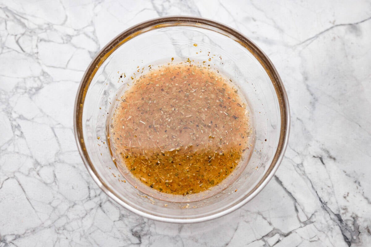 Overhead shot of all of the dressing ingredients added to a bowl and whisked together.