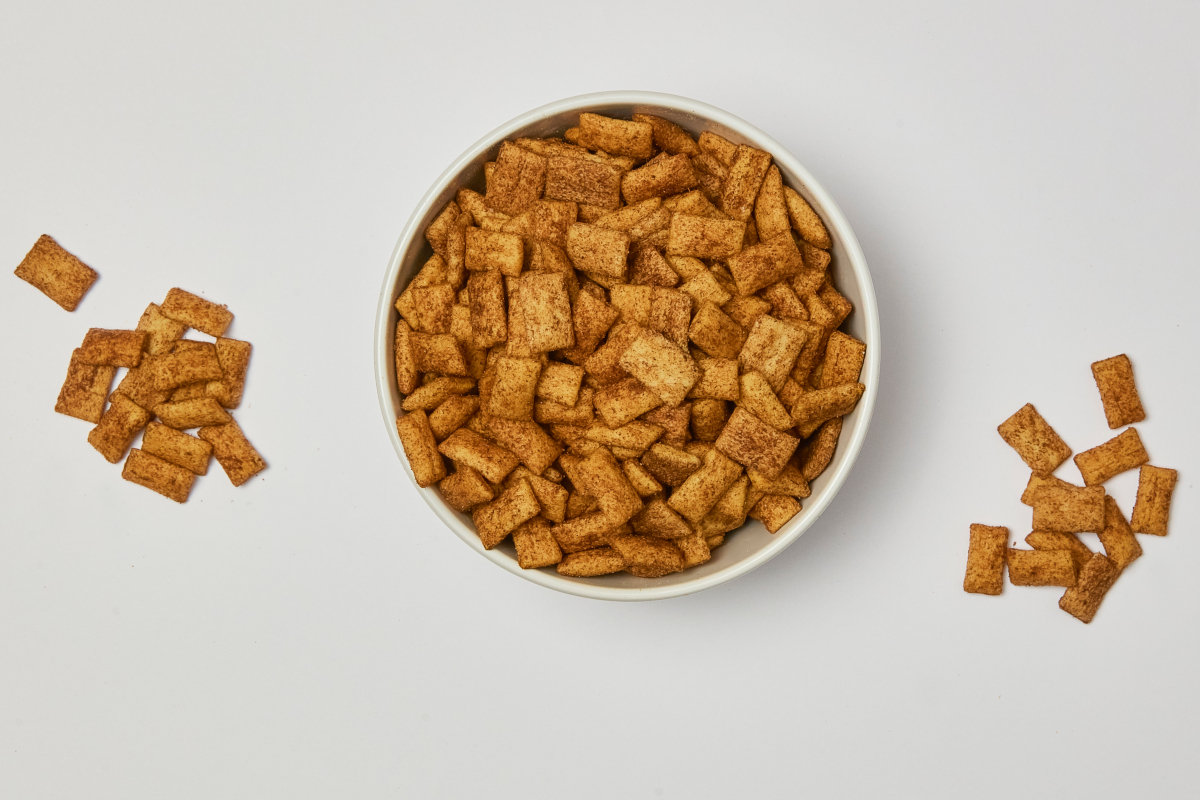 Molino Nicoli-Cinnamon Crunch cereal in a bowl. Crispy, sweet breakfast treat. Delicious cinnamon squares.