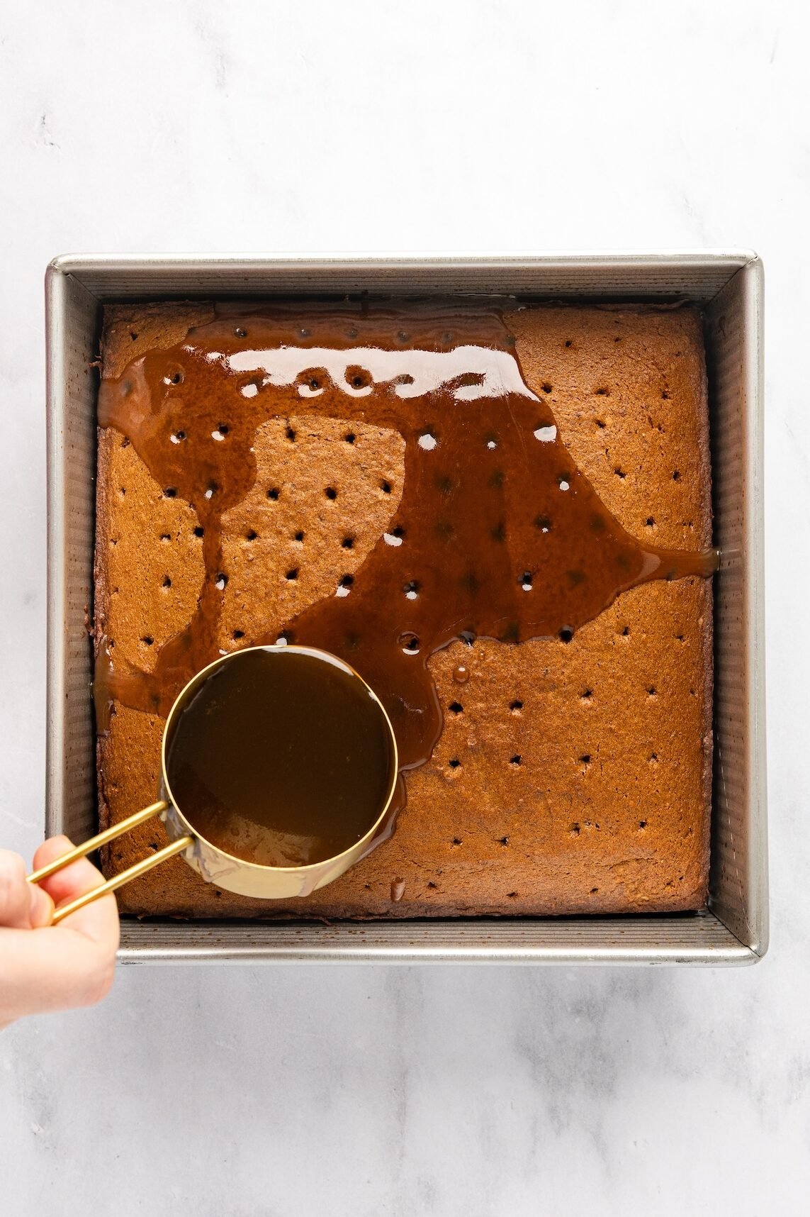 pouring toffee sauce over cake