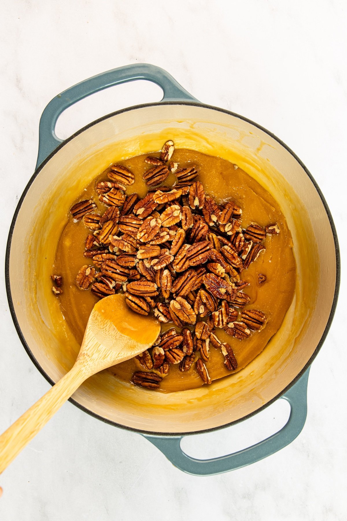 5-quart Dutch oven with vanilla and pecans on top of caramel