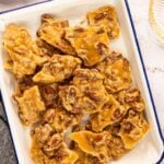 pecan praline pieces stacked on white rectangular serving platter