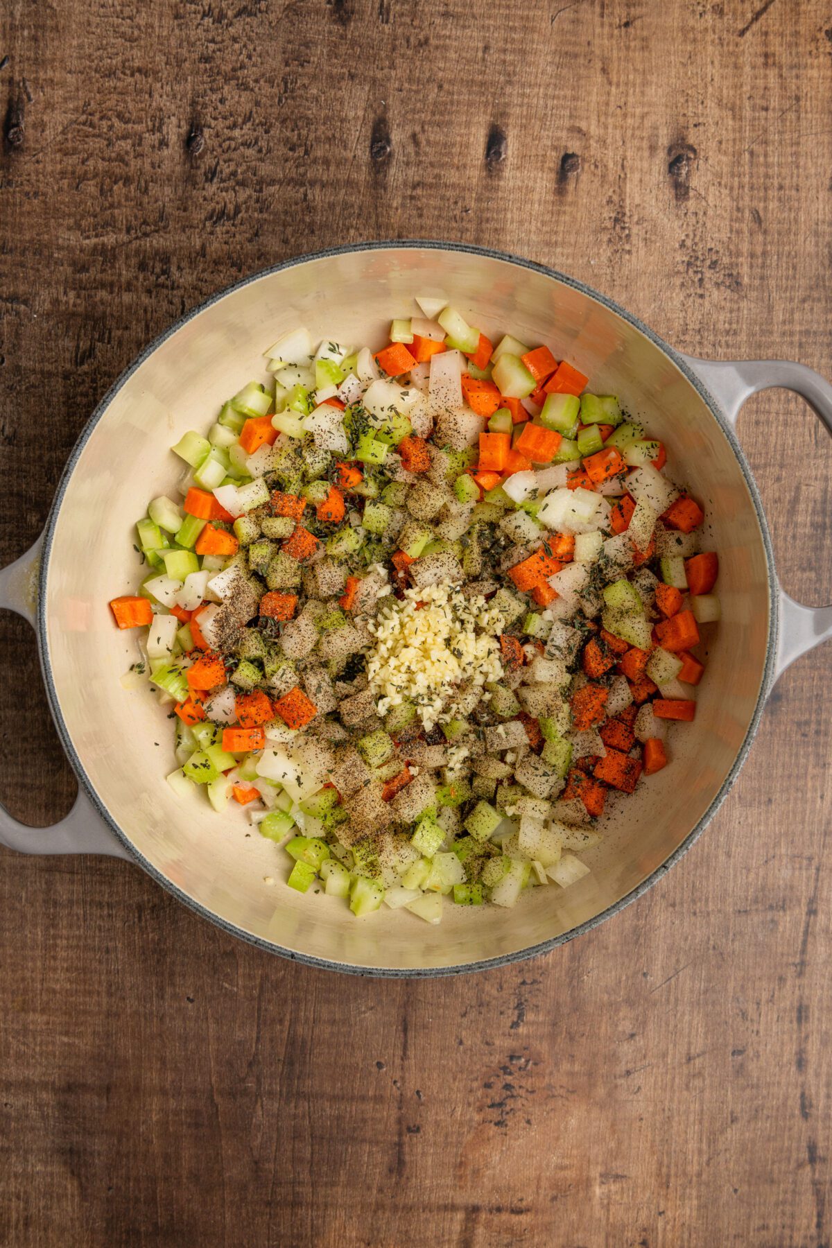 Dutch oven with celery, carrots, onion, garlic, thyme, salt, and pepper