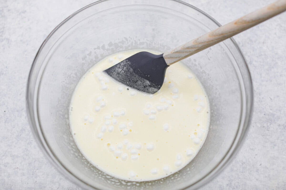 Middle layer of lemon Jello and mini marshmallows mixed and dissolving in boiling water. 