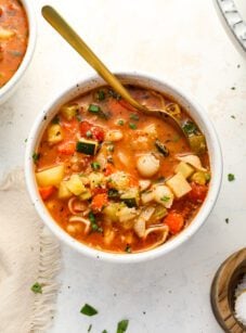 bowl of minestrone soup with spoon and cloth napkin