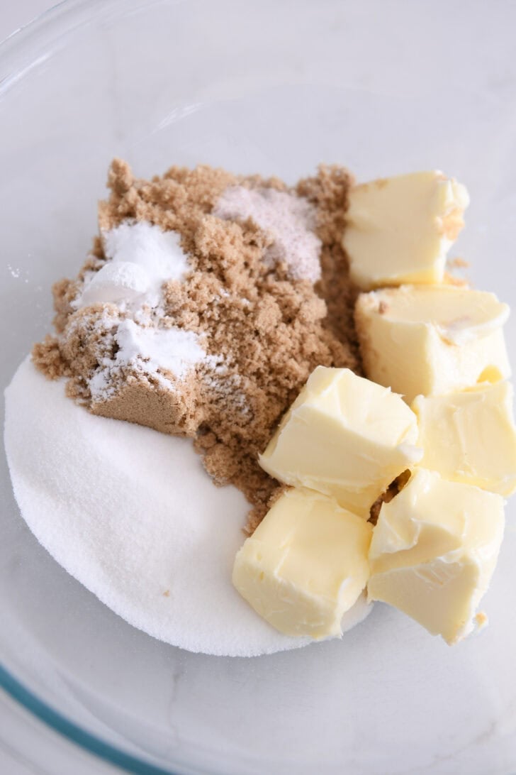 Glass bowl with butter, brown sugar, and granulated sugar.