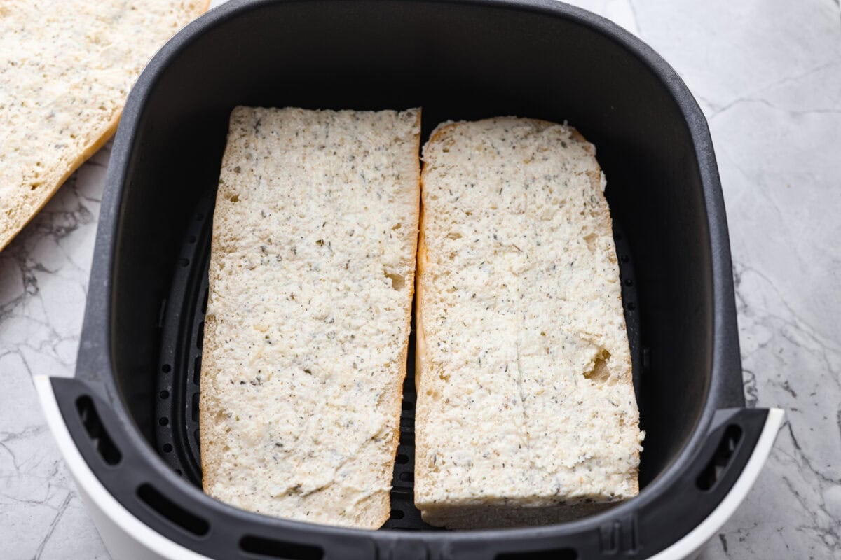 Garlic bread cut and placed in the air fryer basket. 
