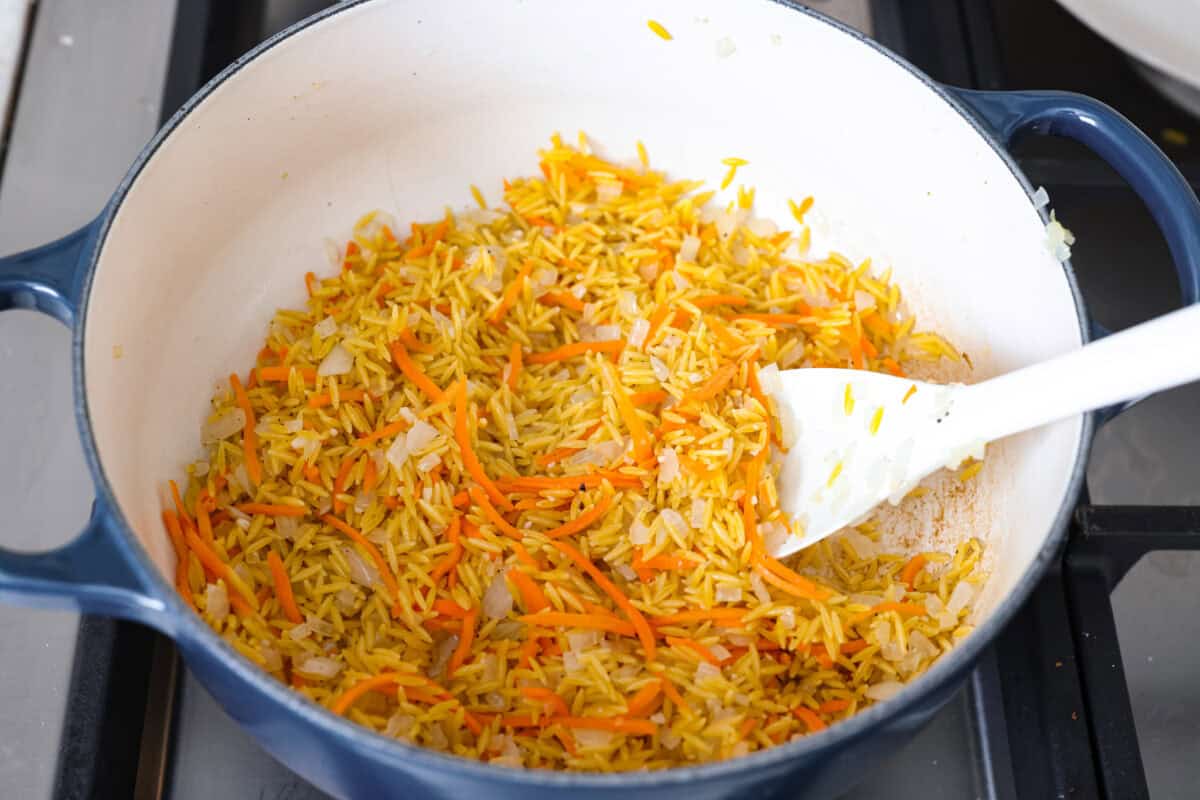 Orzo added to the pan of cooked veggies. 