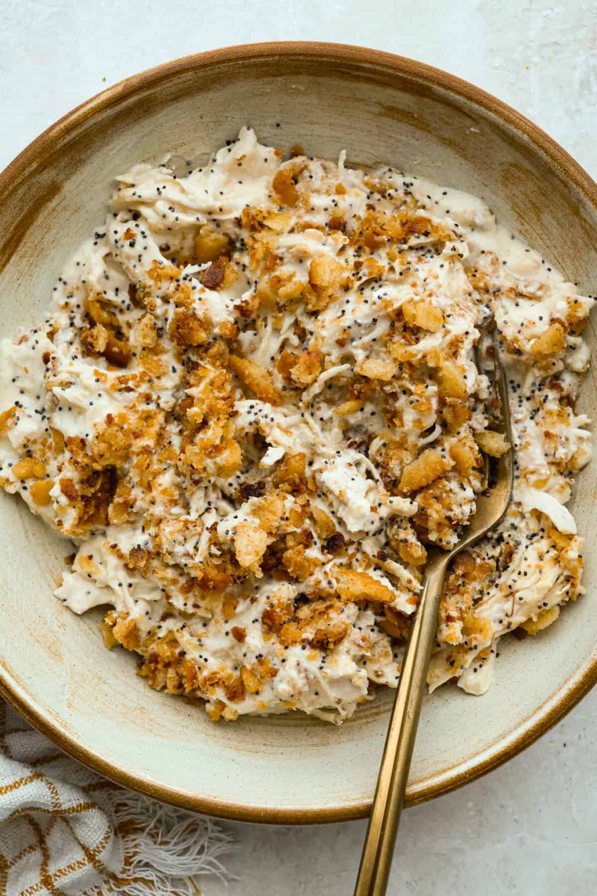 Serving of crockpot poppyseed chicken in a serving bowl.