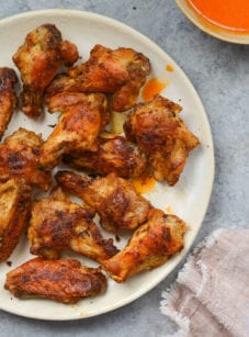 Crispy baked chicken wings on plate.