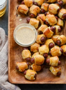 Wooden tray of pigs in a blanket.