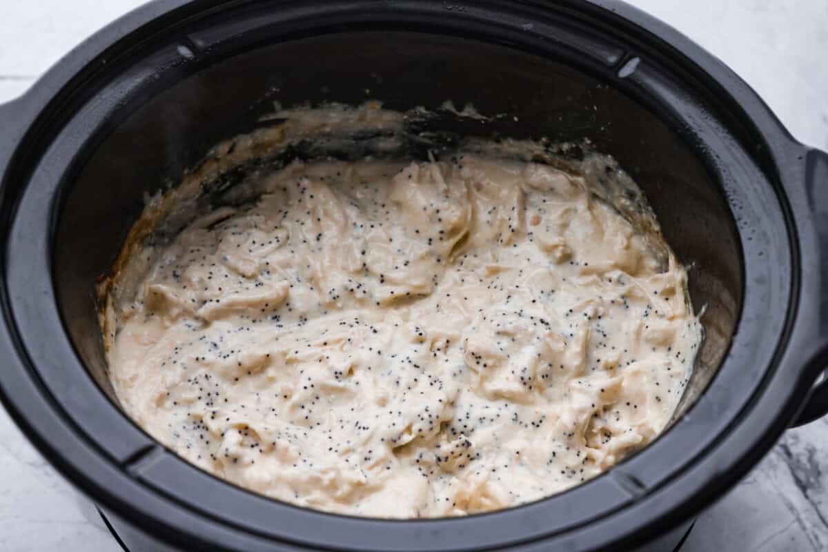 Cooked chicken shredded and poppyseeds added to the crockpot.