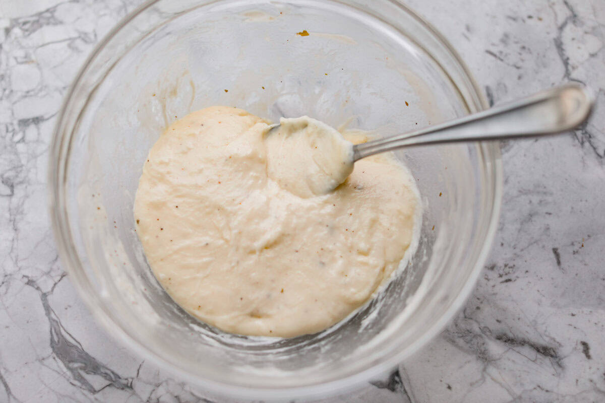 Cheesy ranch sauce for the copycat longhorn parmesan crusted chicken mixed together in a bowl. 