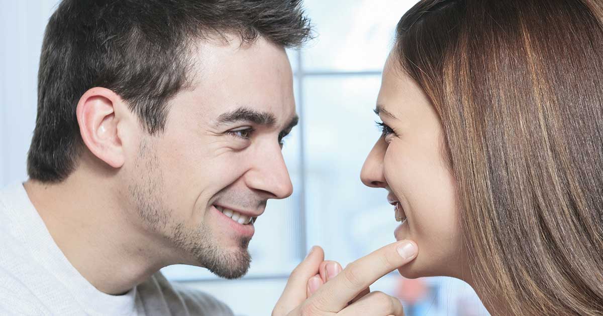 Close-up of couple making eye contact, genuine smile, intimate moment, connection visible