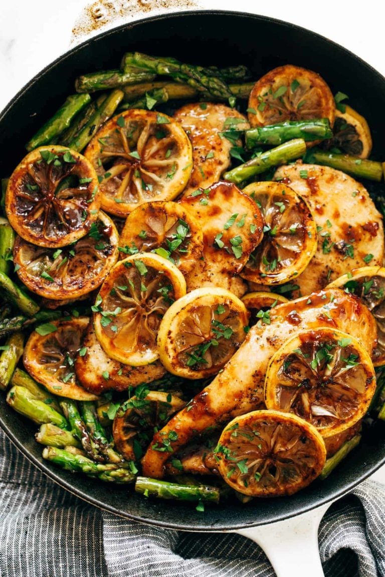 Lemon chicken with asparagus in a skillet.